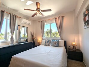 Wake up in this cozy, stylish bedroom! Featuring a plush bed, chic coastal decor, and a cool breeze from the ceiling fan & A/C, it's the perfect retreat after a sun-soaked day.
