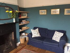 Living room lounge with fireplace, wide screen TV & sofas