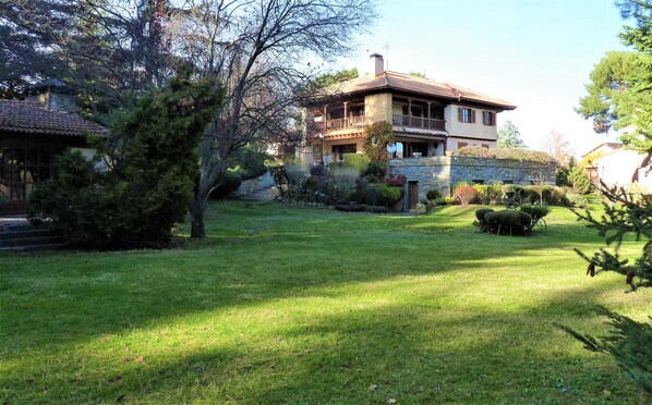 Casa y jardín desde la pista de tenis