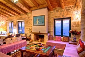 A spacious lounge with six sofas and an open fireplace, perfect for relaxation.