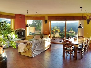 Spacious lounge with 180° panoramic views. Rustic fireplace.