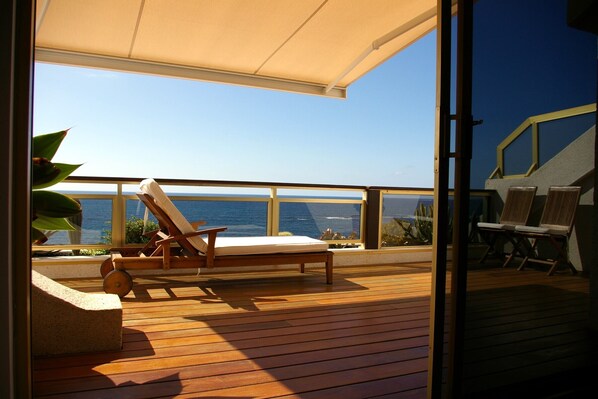 Die Terrasse und den Blick auf den Strand und das Meer