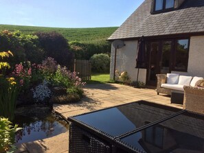 South facing patio with barbecue and dining table and chairs