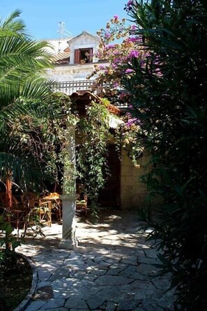 The large and furnished garden packed with plants and flowers surrounds the villa. 