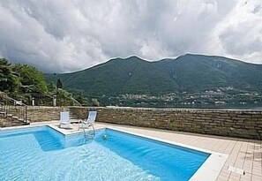 Swimming pool and sunbathing area at "Stylish Lake View Garden Apartment"