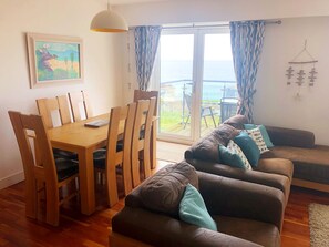 Open plan lounge kitchen diner with balcony and views across the bay