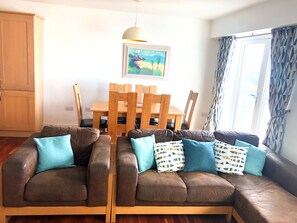 Open plan lounge kitchen diner with balcony and views across the bay