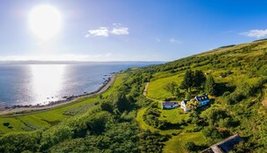 Aerial view of Banlicken Farmhouse, beach below & coastal views