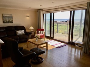 The large sitting room and balcony overlooking the sea.