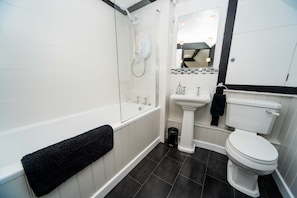 Ample storage, shower above bath, cupboard, WC, heated towel rail & bathmat 