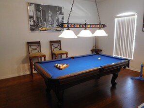 Games room with pool table, table tennis, foosball table and poker table. 