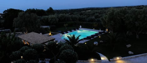 Blick von der Dachterrrasse auf den Swimmingpool in der Abenddämmerung 