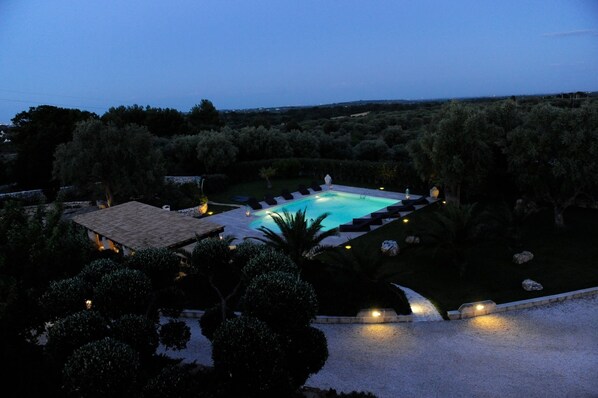 Blick von der Dachterrrasse auf den Swimmingpool in der Abenddämmerung 