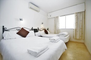 Twin bedroom with two double beds and air conditioning