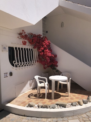 Small patio with table and chairs at the front of the apartment. 