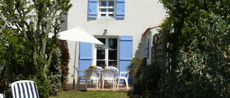 Une maison conçue pour des vacances, avec son  petit jardin et son barbecue