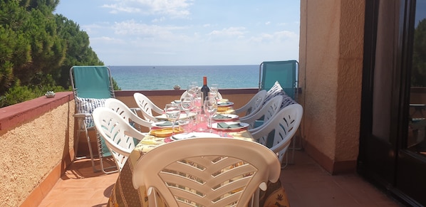 Terraza con vistas a la playa. Mesa para 8, tumbonas, sombrilla.