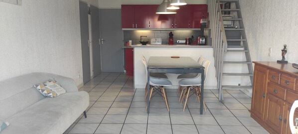 Pièce principale avec coin cuisine et climatisation.
