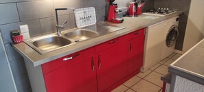 Pièce principale avec coin cuisine et climatisation.