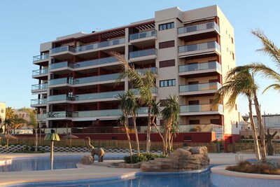 Modern apartment on the beach front line, terrace with sea views and pool 