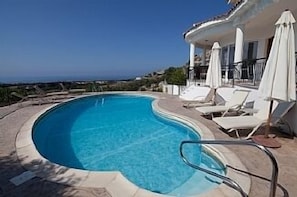 Large kidney shaped pool with Roman steps + ladder at the far end of pool.