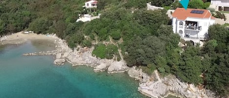 Villa am Meer, Blick in die Bucht mit Sandstrand; der Pfeil markiert die Villa