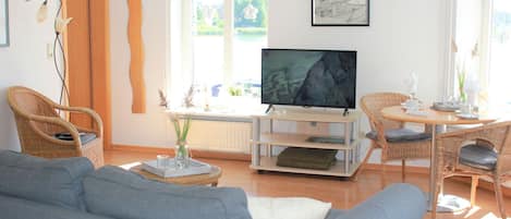 großes Wohnzimmer mit Fernseher und Essbereich mit Blick auf die Schlei