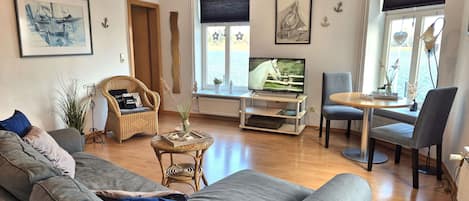 großes Wohnzimmer mit Fernseher und Essbereich mit Blick auf die Schlei
