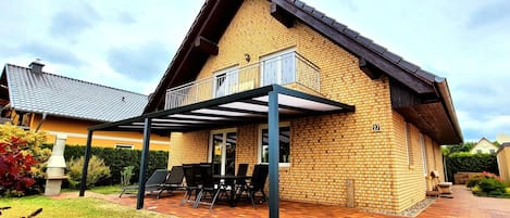 Hausansicht mit Terrassenüberdachung und Balkon 