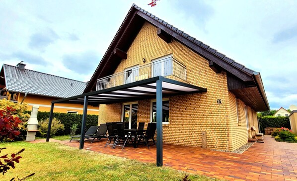 Hausansicht mit Terrassenüberdachung und Balkon 