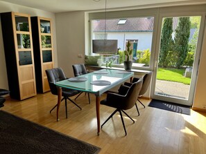 Wohnzimmer mit Esstisch und Blick in den Garten