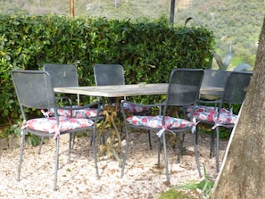 Sitz-/Essecke im Garten unter einem Lärchenbaum für Schatten in der Mittagszeit