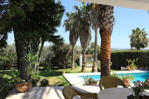 Der Esstisch auf dem überdachten Teil der Terrasse mit Blick in den Garten