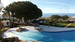 Traumhafte Pool-Landschaft mit viel Rasen, Wasserfällen, Meerblick, Felseninsel