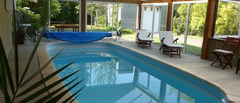 piscine attenante au salon avec vue sur le jardin clos