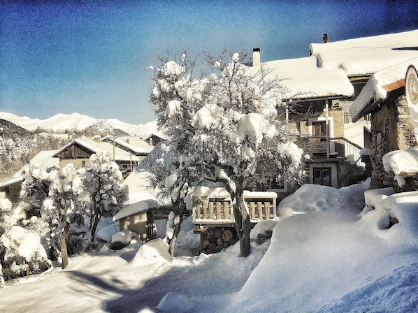 En hiver, vue du jardin vers le gite et sa terrasse