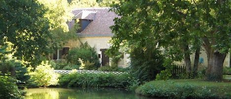 Le gîte est situé dans le parc du moulin de la Follaine, entouré d'eau