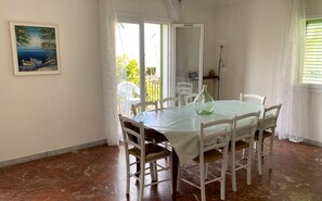 Salle à manger donnant sur un grand balcon avec vue mer