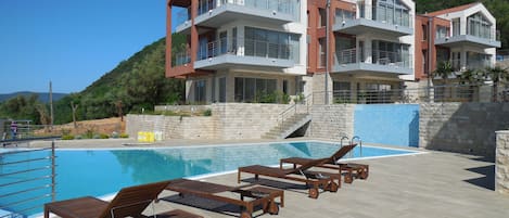 Depuis la piscine, vue sur l'appartement, de face au 1er étage et la terrasse. 