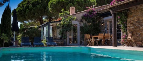 Vue sur la maison en bordure de la piscine.