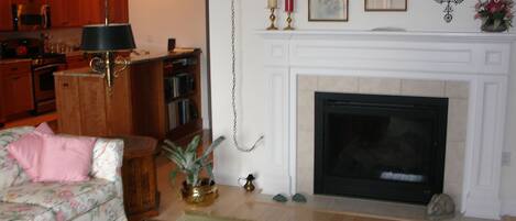 Living room with  two sided fireplace looking into kitchen