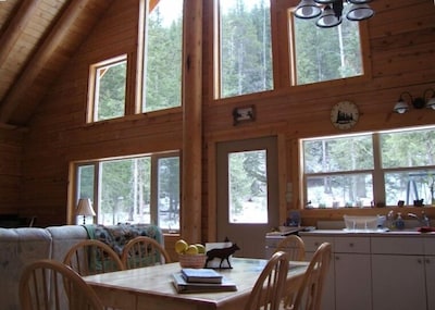 View of living/dining room windows which look out onto an acre of wooded land