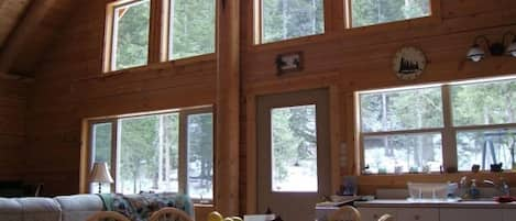 View of living/dining room windows which look out onto an acre of wooded land