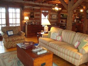 Main floor living room, kitchen area to the right, seeing doors leading to deck