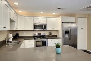 Upgraded kitchen with quartz counters and solid wood cabinets. 