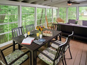 Large screen porch with table and fold-flat couches.