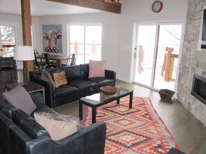 Designer rug and leather furniture, exposed timber beams add to the rustic decor