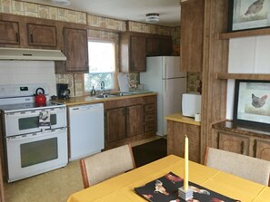 Kitchen has glass top double oven, dishwasher and refrigerator