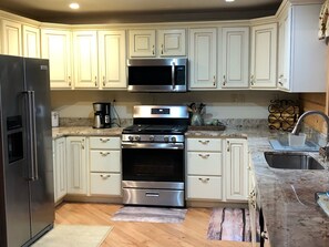 Our updated kitchen with custom granite countertops and stainless appliances