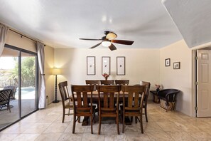 Dining area with views over the backyard and pool, table seats 8